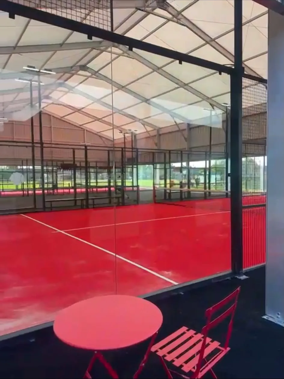Finished indoor padel court with a red playing surface and glass surround, built on new groundworks by DVH Innovations