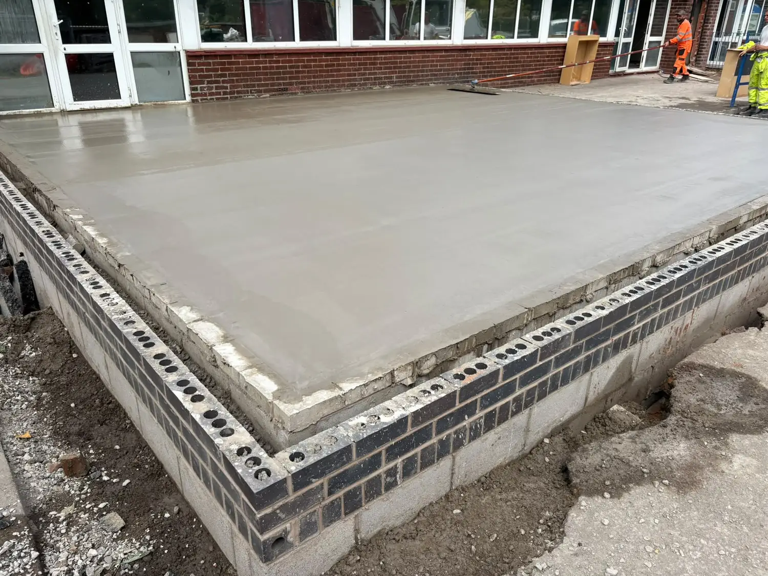 Reinforced concrete slab, power floated, sitting on a blue engineering brick plinth