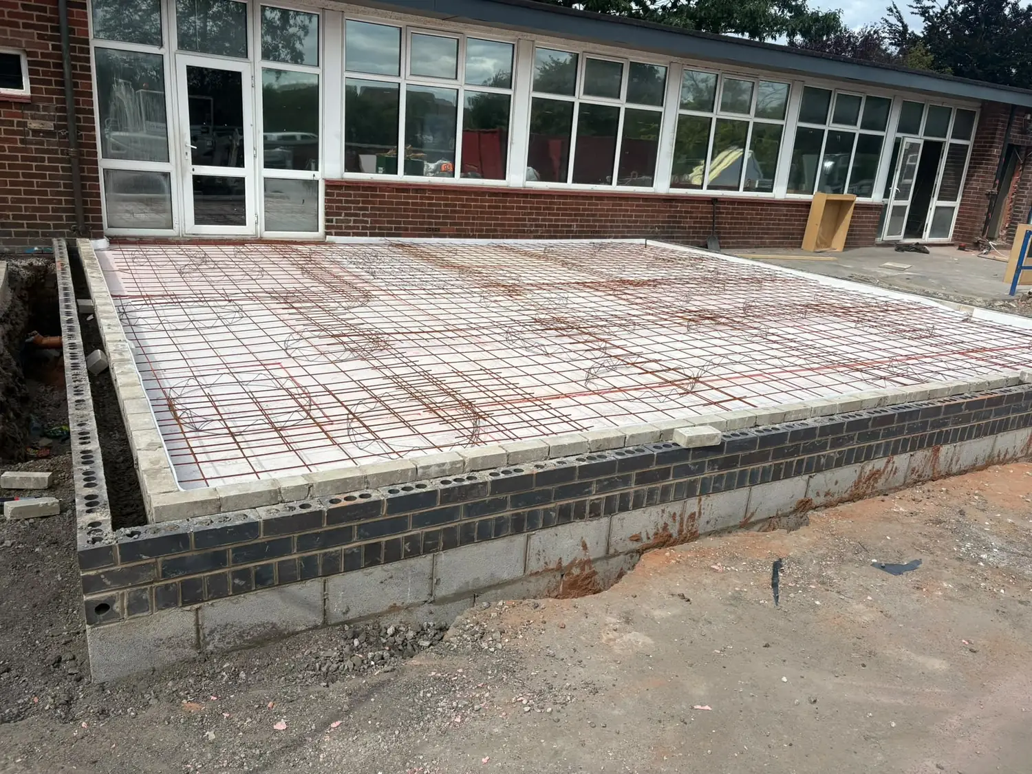 Steel reinforcement mesh and rebar cages tied out over the membrane ready for the pour